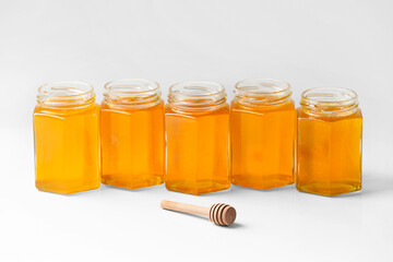 Banks with honey one near the other on a white background.