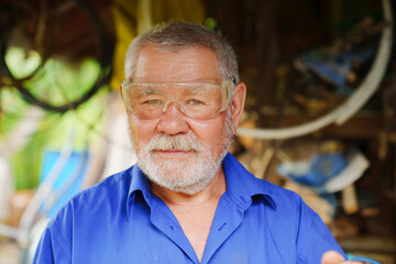 an elderly man in goggles to work with a circular saw