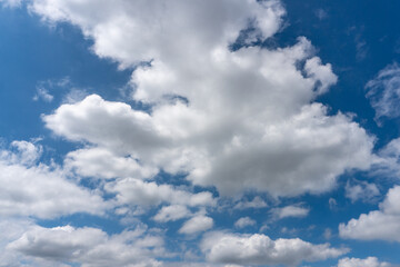 Fluffy White Clouds With Hints of Grey Against Bright Blue Sky