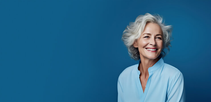 60-year-old smiling woman with gray hair on a blue banner background with copy space. Ai generative