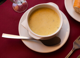 Puree soup of various vegetables served in a plate with necessary table laying