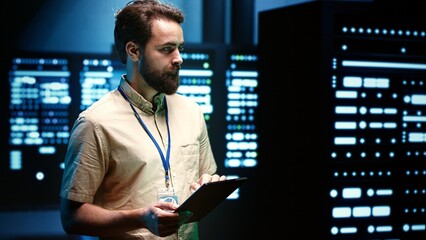 Developer in server room walking through data hardware clusters used for computationally intensive...