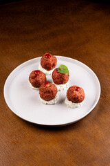 portion of meat dumplings with pepper on wooden table angle view round plate