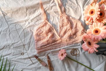 Gentle pink lace bra on the bed. Women tender lingerie, underwear. Top view, close up. Flat lay, beauty blog or social media minimal concept. Present for Valentines, Women’s day