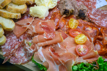 Fresh cuts of French cured sausages, ham, cheeses for party close up