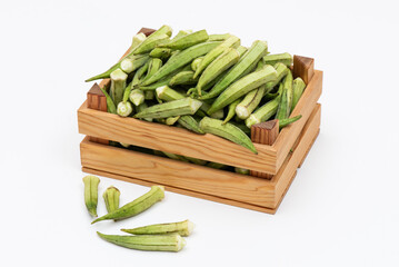 Fresh okra on the wooden container.