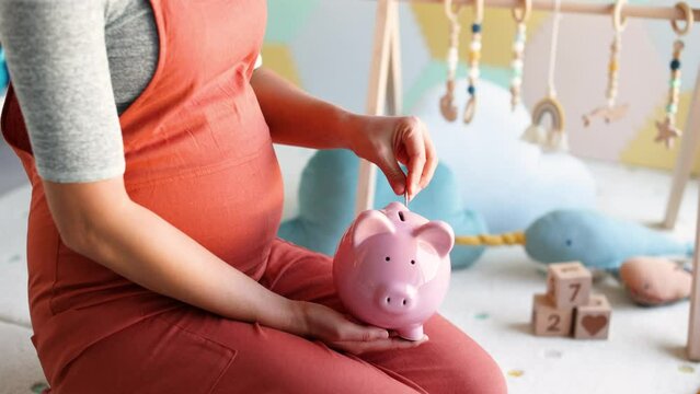 Pregnancy family planning budget. Cost of having a child. Pregnant woman putting money in piggy bank shopping newborn toys and nursery decor with savings. Maternity leave benefits.