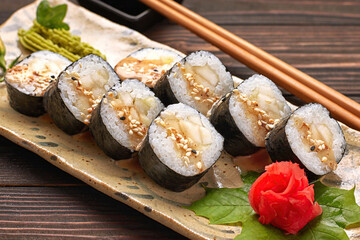 Delicious sushi rolls with wasabi and ginger with chopsticks. Closeup