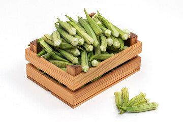 Fresh okra on the wooden container.