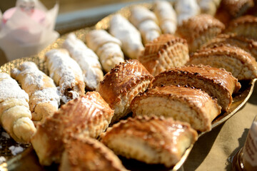 Delicious homemade cakes are on a tray for treating guests. Homemade Caucasian pastries. Home-made confectionery. The concept of lifestyle, baking and spending time at home. Crumbly baking dough