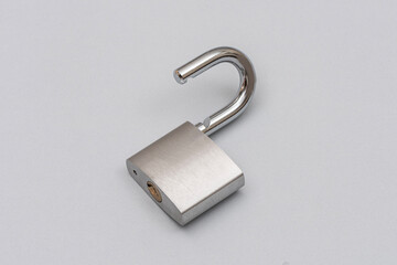 Unlocked silver padlock on the gray background.