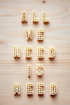 Naklejki Creative transformed expression ‘All we need is weed’ made up of pasta letters on wooden table background 