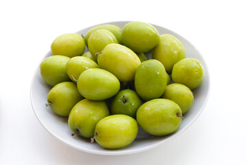 Green jujube fruits on white background.