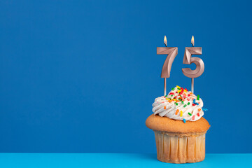pink birthday candle - cupcake on blue base and blue background