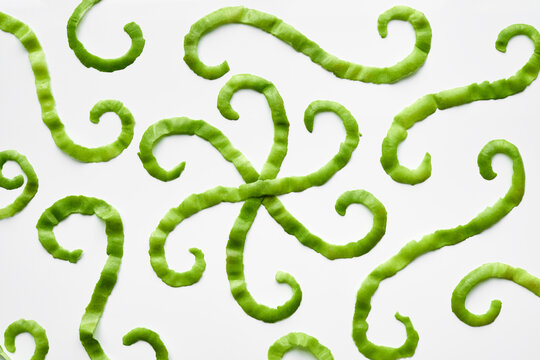 Directly above view of apple skin stripes with curls forming odd figures against white background   