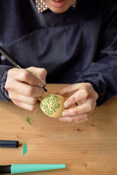Woman drawing on Easter egg