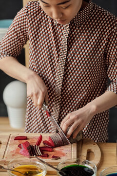 Woman cutting beet for dyeing eggs