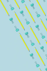 Pencil and binder clip flat lay on blue background