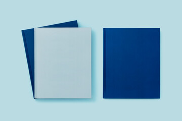 Blue books mockup with blank cover on blue background.