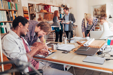 Young and diverse group of designers working on a project together in the office
