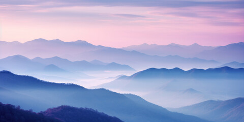 Fototapeta premium The mountains are shrouded in mist, and the last traces of daylight lend a tranquil, mystical quality to the scene. A twilight shot of autumn mountains under a fading pink and purple sky.
