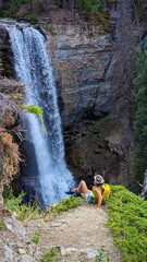 person is taking pictures of waterfall in the forest
