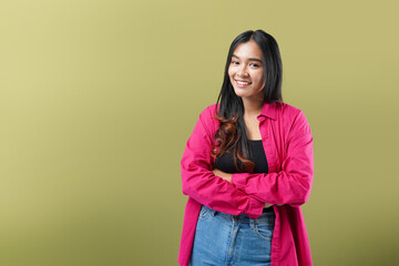 Fototapeta premium Photo of Asian woman isolated on green background keeping the arms crossed in frontal position.