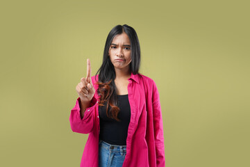 Photo of Expression No. Young asian woman serious and confident  showing stop, standing over green background