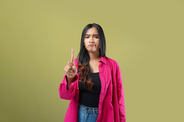 Photo of Expression No. Young asian woman serious and confident showing stop, standing over green background