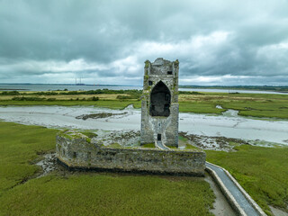 Aerial view of Carrigafoyle castle ruins in Ireland, large Gothic tower house surrounded by water