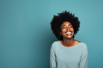 Fototapeta na wymiar portrait of black woman smiling in a studio, plain colour background