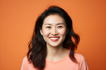portrait of asian woman smiling in a studio, plain colour background