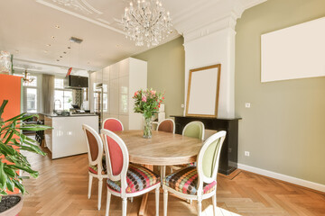 a dining room with wood flooring and white trim on the walls there is a chandel in the center of the room