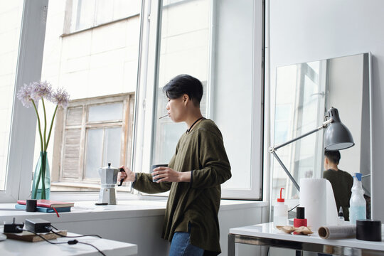Smoking tattoo artist taking espresso maker