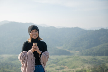woman traveler drinks coffee with view of mountain landscape. young tourist woman drinks hot drink...