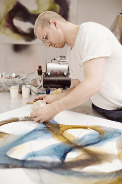 Man in process of creating abstract painting