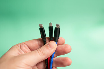 Folded USB lightning cable isolated over the green background. Three types of peripheral...