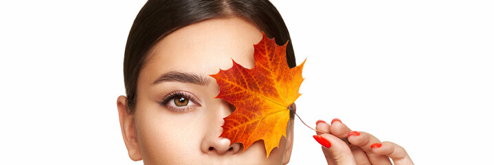 Portrait of beautiful young woman with autumn leafs. Healthy clean fresh skin natural make up...