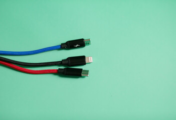 Folded USB lightning cable isolated over the green background. Three types of peripheral...