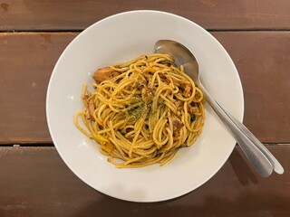 Top view of pasta spaghetti with spicy tuna sauce and oregano served on a white plate