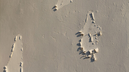 Background and texture of an outdoor wall paint that has peeled off due to age and weather.