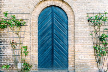 White brick wall and stylish blue arched door