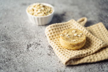 Oatmeal Soap with cotton fabric, soap, over gray background. Zero waste, natural organic bathroom tools. Plastic free life. Ecological skin care, body treatment concept