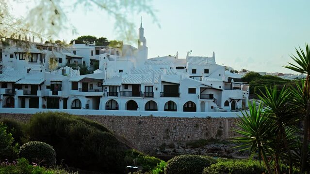 Beautiful panoramic view of Binibeca Coastal Village with whitewashed houses. An early morning sunrise over Binibeca Vell a Calm Cove Resort in Menorca, Balearic Islands, Spain.