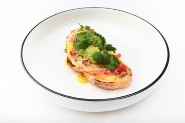 Spanish tapas is traditional sandwich snack for wine or beer - crab meat on piece of bread with tomatoes and avocado puree. Delicious crab dish. Crab bruschetta.Copy space. Isolated object.
