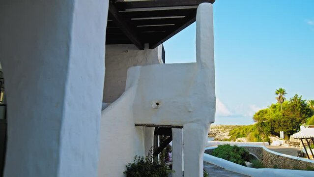 Narrow Whitewashed Streets in a tourist resort Binibeca Vell in Menorca, Spain. Beautiful small village town on the Balearic Islands with traditional brown wooden windows and doors in Europe.