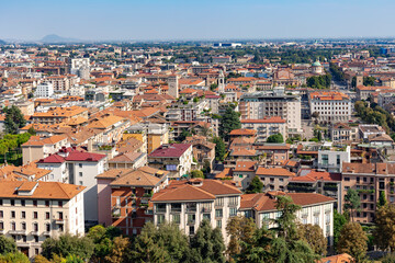 Fototapeta na wymiar Aerial view of the old town Bergamo in northern Italy with red tiled roofs of houses on the background of the Alpine mountains. Bergamo is a city in the alpine Lombardy region.