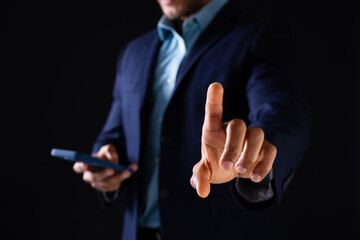 Biracial businessman using smartphone and pointing on black background