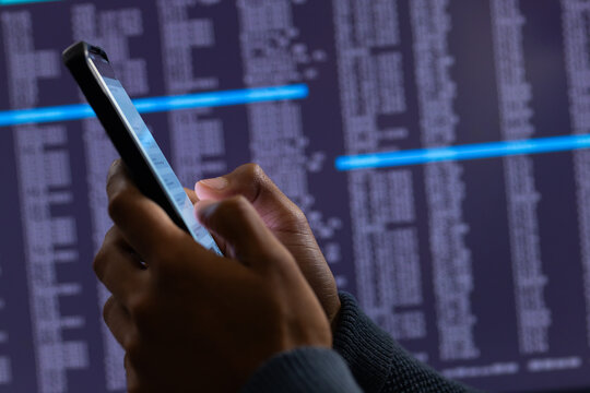 Biracial businessman using smartphone and data processing on grey background