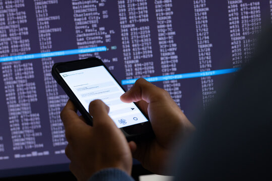 Biracial businessman using smartphone and data processing on grey background